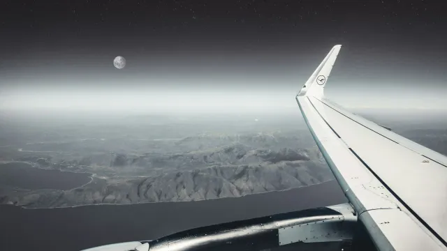 Blick aus dem Flugzeugfenster auf Tragfläche, Mond und Küste bei Nacht – Sex in der Fernbeziehung