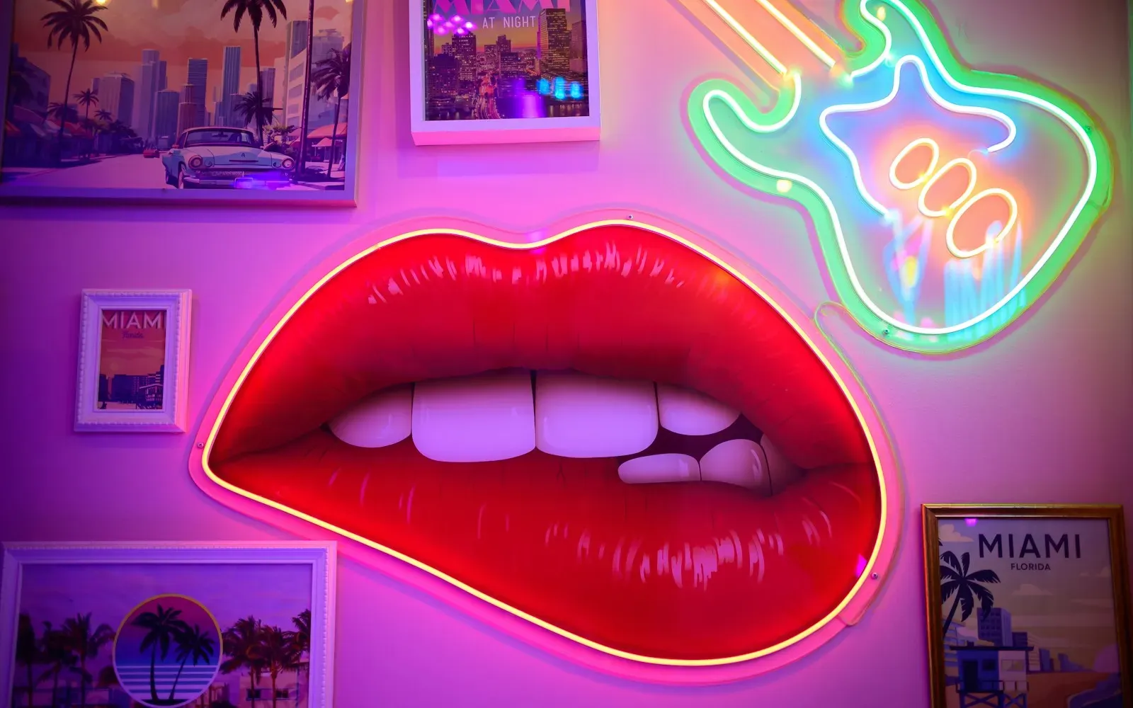 Leuchtende rote Neon-Lippen an einer pinken Wand – Sexting-Spiele für Paare und Chat-Partner