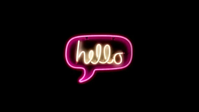 Pinke Neon-Sprechblase mit dem englischen Wort hello vor schwarzem Hintergrund – Dirty Talk auf Englisch
